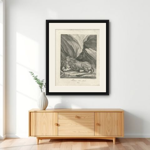 Antique Print of a sleeping Lion in a mountainous landscape, shown framed on a wall